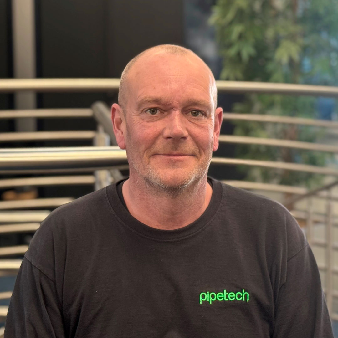 A bald man wearing a black branded t-shirt.