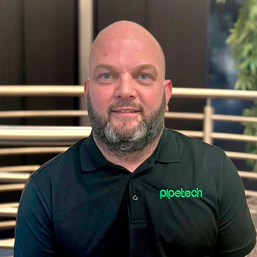 A Pipetech team ember wearing a black branded polo shirt.