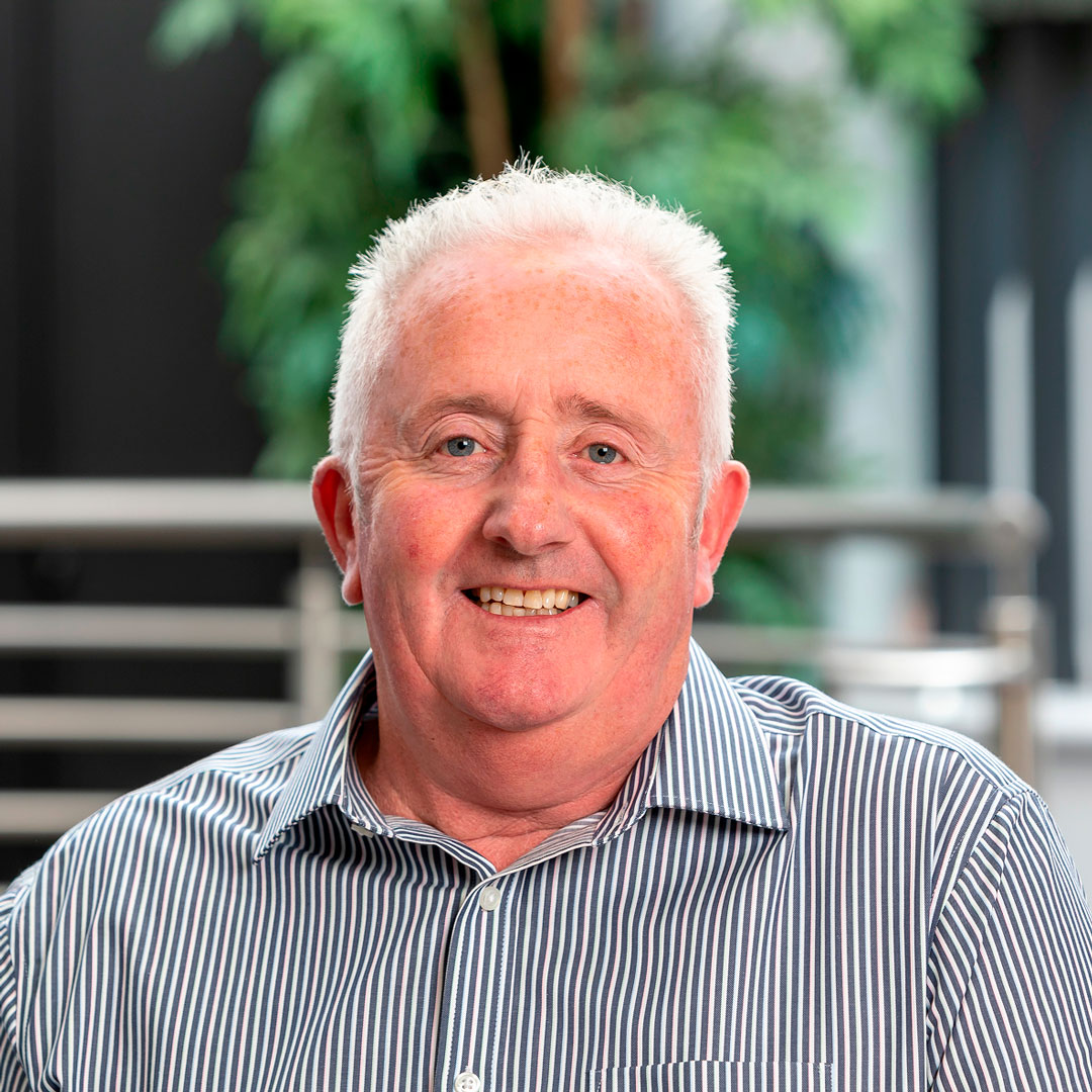 Man with white hair wearing a black and white striped shirt.